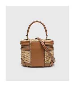 Braune PU-Leder und geflochtene Stroh Box Tasche Detail mit Tragegriff und Schultergurt.