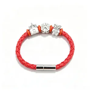 Detail view of red braided leather bracelet with silver magnetic clasp and cute metal charms.