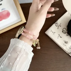 Close-up detail van het roze kraal smartwatch vervangingsbandje in Chinese stijl met bedels.