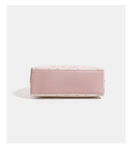 Detailed view of the pink leather handbag bottom with cute cat debossed patterns and sturdy base.