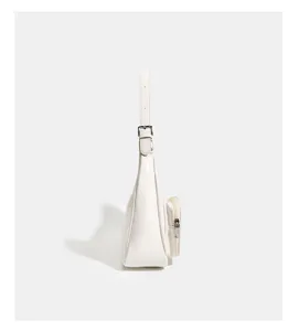 Detailed side view of white patent leather women shoulder bag featuring external pocket and buckle.