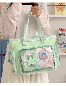Vista dettagliata della borsa ita a pois verde chiaro con finestra frontale e badge anime.
