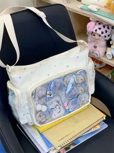 Detail shot of white star ita bag with transparent window, showing anime badges and straps.