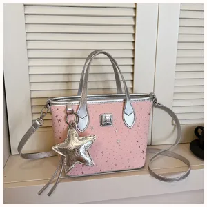 Dettaglio borsa a tracolla rosa, stampa stelle argentate, manici metallici e ciondolo.
