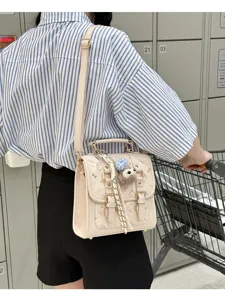 Detailed view of stylish retro vintage shoulder bag with cute pattern and plush pendant.