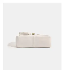 White handbag bottom detail view, showing clean leather texture and durable stitching structure.