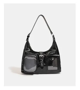 Detail view of black patent leather ita shoulder bag with clear front pockets and buckle.