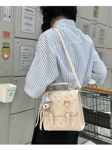 Chic small backpack with cute cat print, bow accents, and plush keychain for daily commute.