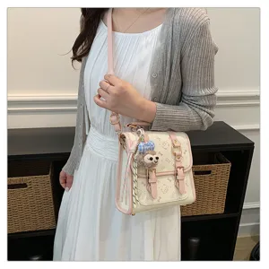 Detail view of pink student style backpack with cute bunny plush pendant and stylish design.