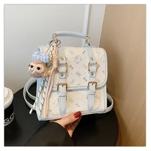 Detail shot of the cute blue and white mini backpack with plush pendant and straps.