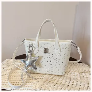 Borsa tote in pelle bianca con stelle argentate, ciondolo a stella e tracolla.