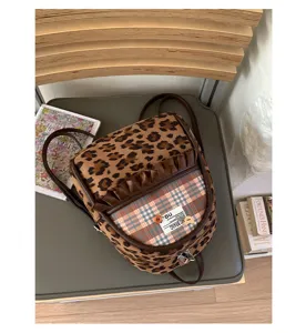 Detail view of a retro women leopard print and plaid mini backpack with ruffle pocket and straps.