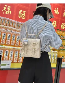 Beige vintage mini backpack for women, stylish cute satchel bag with bow doll charm.