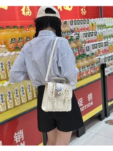 White vintage mini backpack for women, chic commuter shoulder bag with cute plush charm.