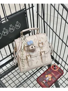 Chic beige PU leather mini backpack for women, featuring cute cat print and stylish double buckle closure.