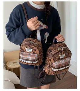 Detailed view of the vintage brown printed mini backpack with plaid front pocket and straps.