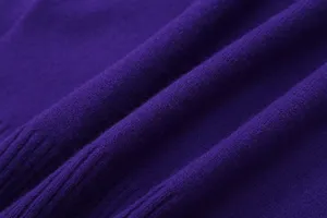 Close-up detail of purple knitwear fabric, showing soft texture and fine woven grain.