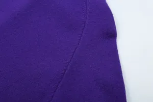 Purple knit sweater fabric detail view, fine texture and stitching closeup showing quality.