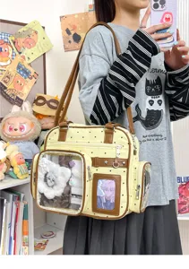 Detail view of the cute yellow polka dot ita bag with double transparent window and straps.