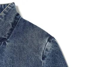 Close-up detailweergave van dames denim jas kraag en schouder met gewassen textuur.