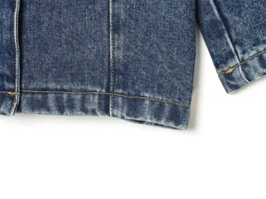 Close-up van blauw denim jas detail met contrasterende gele stiksels en wassing.