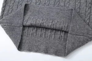 Grey cable knit sweater detail shot, cozy ribbed hem texture, classic winter fashion apparel view.