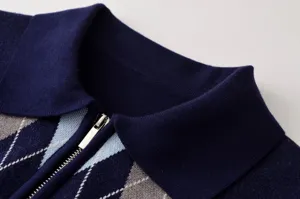 Primer plano de un polo de punto azul marino para mujer con elegante patrón de rombos y cremallera.