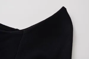 Détail de tissu en tricot noir, texture côtelée, gros plan de vêtement minimaliste mode.