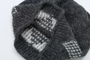 Primo piano della struttura in tessuto lavorato a maglia jacquard grigio scuro, morbido e caldo.