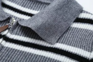 Dettaglio ravvicinato del maglione polo da donna in maglia con fantasia a righe e zip.