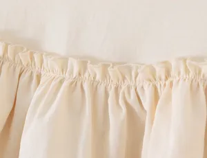 Beige volanten rok detail close-up, zachte textuur, elegant geplooid tiered design