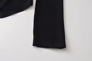 Vue détaillée du haut en tricot noir pour femmes, texture douce et tissu confortable.