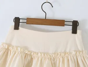 Gedetailleerde close-up van een beige gelaagde minirok met mooie ruches en hoge taille.