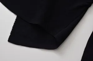 Gros plan détaillé du tissu en tricot côtelé noir pour pull femme avec une texture fine.