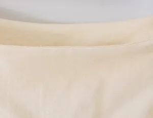 Detailopname van de beige rokstof, met fijne stiksels en een zachte textuur.