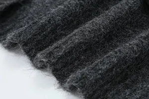 Primo piano di un tessuto in maglia soffice grigio scuro, ideale per capi invernali.