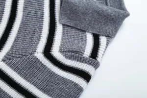 Primo piano dettagliato del colletto del maglione in maglia a righe grigio nero e bianco.