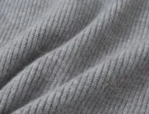 Nahaufnahme der grauen Rippstrick-Gewebe-Textur, die weiches und warmes Material zeigt.