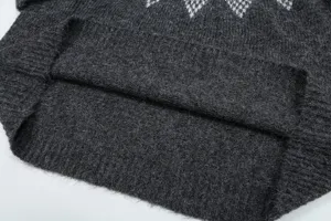 Primo piano della trama del maglione in tessuto felpato grigio scuro e dettaglio orlo