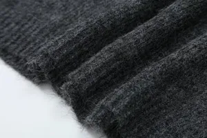 Dettaglio tessuto maglione lavorato a maglia grigio scuro, morbida trama soffice.
