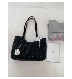 Detailed view of black polka dot tote bag with cute bunny charm, spacious daily casual shoulder bag.
