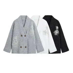 Close-up of women's knit cardigan featuring V-neck, double buttons, and pearl bead embroidery.