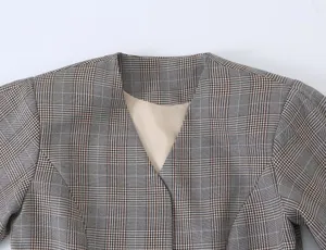 Detail view of stylish women's V-neck plaid blazer jacket, casual European fashion design.