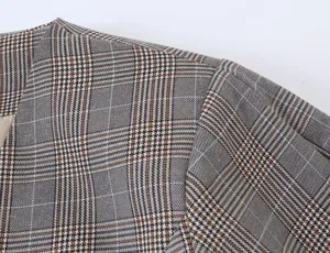 Close-up detailed view of the stylish plaid blazer fabric, showcasing fine stitching and texture.