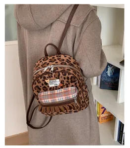 Detail shot of retro velvet leopard print mini backpack with plaid pocket and ruffle detail.
