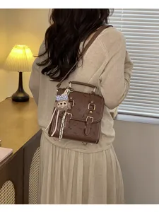Vintage brown faux leather backpack for women, chic school bag with cute plush pendant.