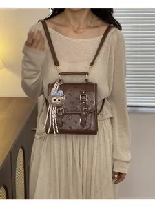 Brown retro PU leather women backpack with embossed cat patterns and cute plush pendant.
