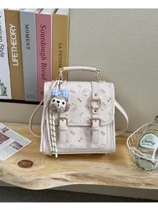 Detail view of the elegant beige faux leather backpack featuring cute cat patterns and bow prints.