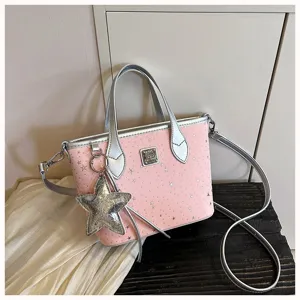 Dettaglio borsa a tracolla in ecopelle rosa con manici argentati e ciondolo a stella.