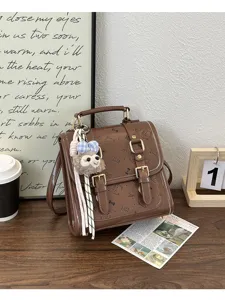 Brown retro faux leather backpack with cute cat prints, gold buckles and fuzzy plush pendant.